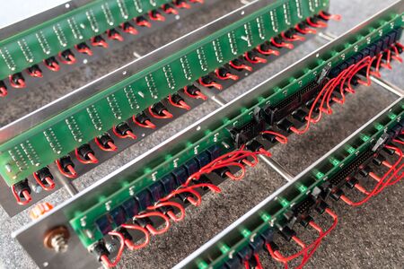 Close-up of a metal panel with microchips connected to each other with red wires in the manufacture of electronic equipment. The concept of complex technical equipment at the factoryの写真素材