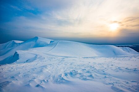 Bewitching view of the foggy sunny ski slope against the backdrop of a sunny cloudy sky. Winter...