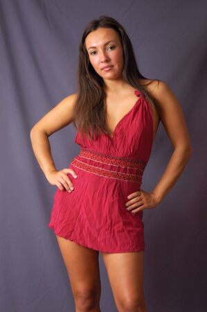 Tan girl posing in red dressの写真素材