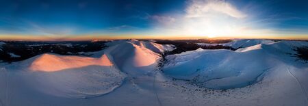 Aerial view of the stunning winter panorama of the snowy slopes and hills among the lush white...