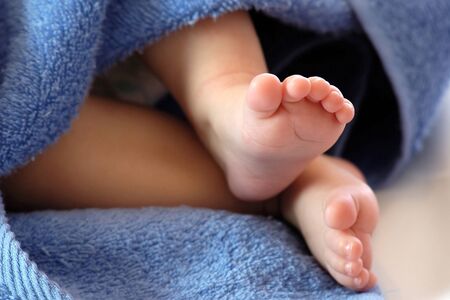 Four month old baby legs in blue towelの写真素材