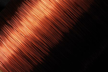 Close-up large coil of thin copper wire in the production of technical parts. Concept of electrical appliances and household goods. Advertising spaceの写真素材