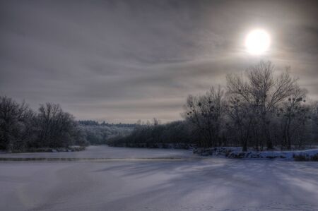 Mystical mesmerizing winter landscape a thick layer of snow lies in the forest among the trees. Backdrop of a foggy sky and the breaking sun on a frosty winter dayの写真素材
