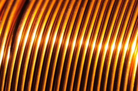 Close-up of a coil of red copper wire in the manufacture of electrical parts. Concept of electrical appliances and repair. Advertising spaceの写真素材