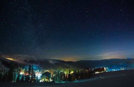 European ski resort with steam and smoke, located among the picturesque forest mountain hills at...