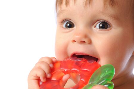 Little one year baby holds on hand colorful teething toy. Child teeth erupt toy. Portrait on isolated white backgroundの写真素材