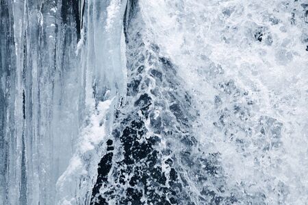 Beautiful mountain waterfall covered in ice. Winter landscape. Frozen creek in the mountains