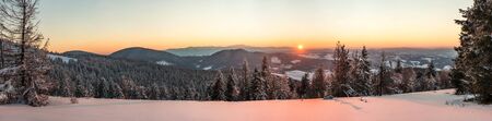 Top view of a beautiful mesmerizing view of the ski slope with ski trails located in the mountains on a sunny winter frosty evening. Vacation and tourism concept in winter. Copyspaceの写真素材