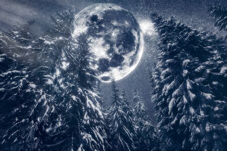 Full moon rising above the winter valley covered with fresh snow. Fantastic milky way in a starry sky. Christmas night.の写真素材