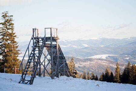Landscape of sunset above coniferous forest and old ski jump on clear winter day. Landscape of winter wonderland nature conceptの写真素材