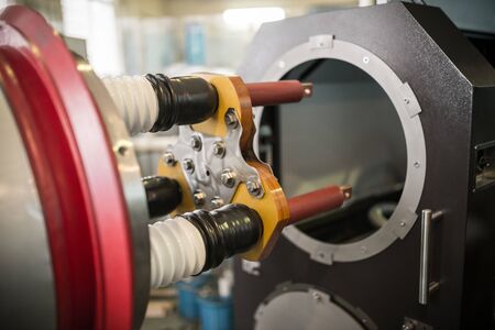 Three copper clems for connecting high voltage cables with ceramic cylinders in drum of test benchの写真素材