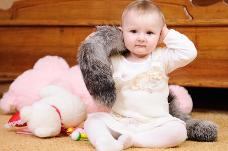 Cute child in knitted baby clothes on floorの写真素材