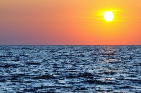 Beautiful colorful sunset over wavy waters of Black sea in Crimea on summer day. Natural landscape background and wallpaperの写真素材