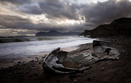 Ocean, old broken boat on shoreの写真素材