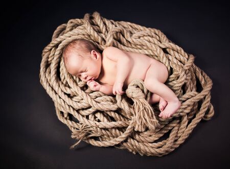 Front view of cute newborn baby touching face with tiny hands during sleep. Sweet infant taking nap...