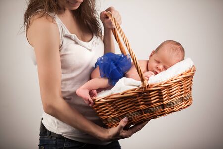 Mother holding basket with sleeping babyの写真素材