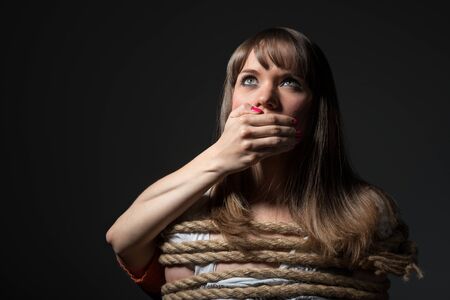 Young woman tied up with rope.の写真素材