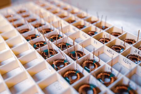 Many twisted copper coils lie in the compartments for the further production of electronic...