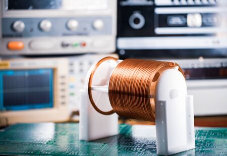 Close-up large and small coils with copper wire stand on a green microcircuit at a factory of classified military equipment. Super secret high-frequency components and equipment conceptの写真素材