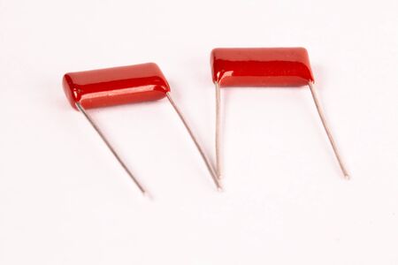 Close-up red capacitors lie on a white table during the production of office equipment and powerful...