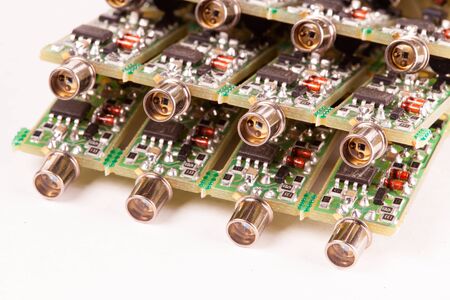 Close-up of four small microcircuits PCB with the output for the wire lying on a white table....