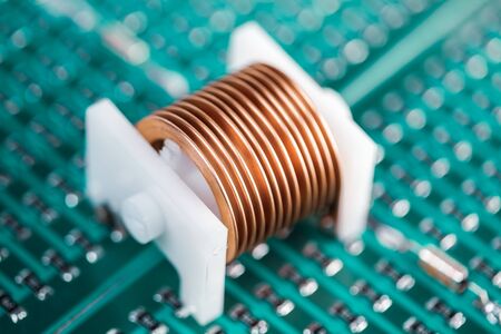 Close-up metal copper wire put on a plastic cork lies on a green microcircuit. Concept for the production of powerful graphics cards and computers and for miningの写真素材
