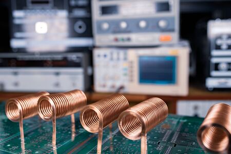 Close-up of high-frequency copper wire on green microcircuit on background of numerous blurry computers. Concept production of super modern high-tech components for transceiver appliancesの写真素材