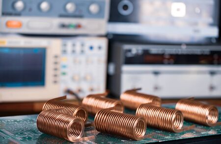 Close-up of high-frequency copper wire on green microcircuit on background of numerous blurry computers. Concept production of super modern high-tech components for transceiver appliancesの写真素材