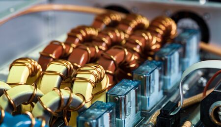 Top view close-up of blue yellow and red coils wrapped in copper wire connected to a microcircuit. Concept of household manufacturing parts and shipbuilding productionの写真素材