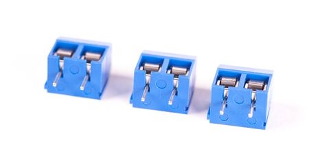 Close-up small blue connector parts lie on a white background. Concept for the production of...