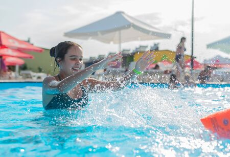 Teenage girl swims in the clear blue waterの写真素材