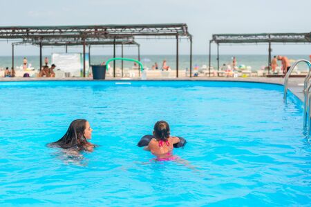 Two little sisters girls are swimmingの写真素材