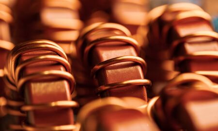 Close-up of yellow and blue coils wrapped on iron powder cores in the factory for the production of industrial and domestic equipment, refrigerators and freezers. Concept production of transmitterの写真素材