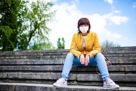 Pretty youthful middle-aged woman in white medical maskの写真素材