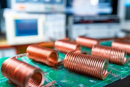 Close-up of high-frequency copper wire on green microcircuit on background of numerous blurry computers. Concept production of super modern high-tech components for transceiver appliancesの写真素材