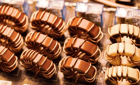 Top view close-up of blue yellow and red coils wrapped in copper wire connected to a microcircuit....