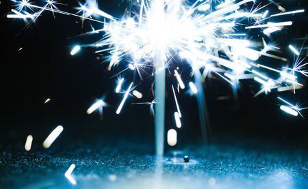 Close-up of blue sparkles of a burning fire on a black background in honor of the holiday.の写真素材
