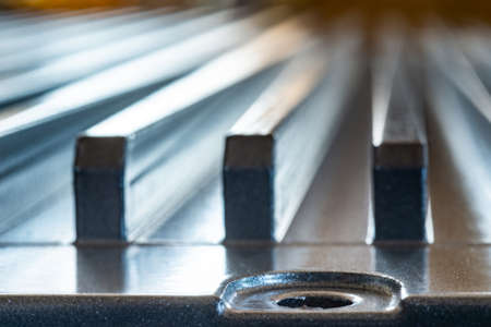 Close-up of a fluted metal surface with bolt hole on an unidentified automatic control device in a...