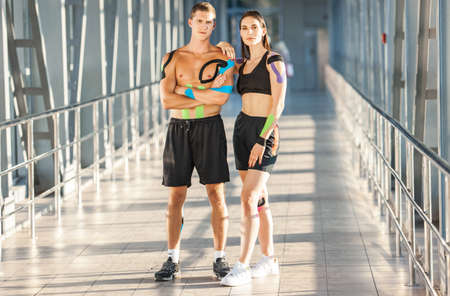Young sports couple with kinesiological taping posing indoors.の写真素材