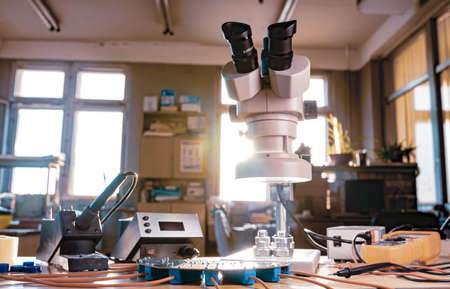 Large modern electron microscope. Microwave coaxial connector and electronic digital multimeter on workshop table. Research of high-frequency radio electronic components in a scientific laboratoryの写真素材