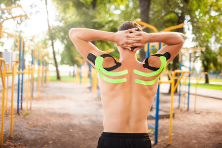 Unrecognizable man with elastic tapes posing at sports ground.の写真素材