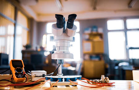 Large modern electron microscope. Microwave coaxial connector and electronic digital multimeter on workshop table. Research of high-frequency radio electronic components in a scientific laboratoryの写真素材