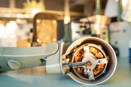 Close-up of an ironmotor from home cooling fan lies on a table during preventive cleaning,...
