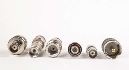 Microwave coaxial adapter UHF Male To N Female connector. Concept of radio details. High frequency component with a metallic covering on white backgroundの写真素材