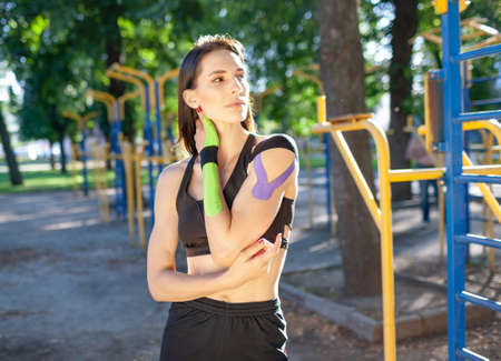 Sports woman with kinesiological taping posing outdoors.の写真素材