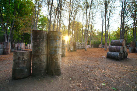 Lots of old round barrels in the paintball baseの写真素材