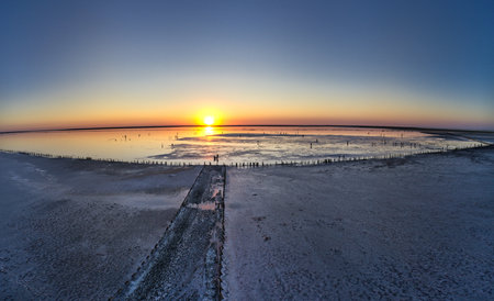 Top view of a shiny salty pink lake and a path along itの写真素材