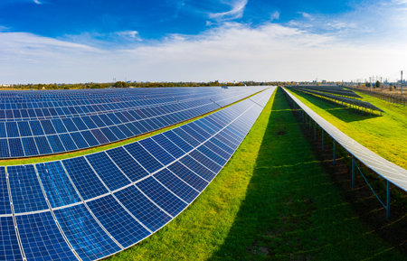 Huge solar power plant to use solar energy in a picturesque green field in Ukraine. Aerial panoramic...