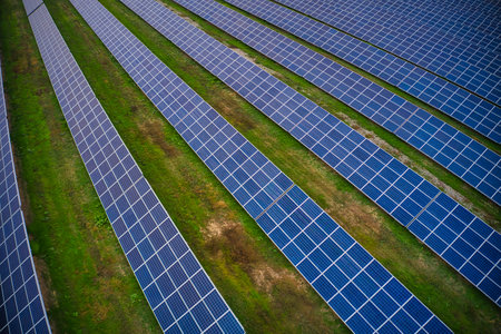 Huge solar power plant to use solar energy in a picturesque green field in Ukraine. Aerial panoramic...