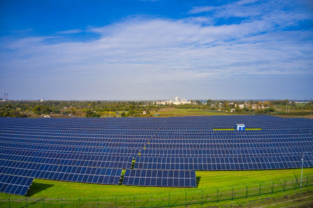 Huge solar power plant to use solar energy in a picturesque green field in Ukraine. Aerial panoramic...